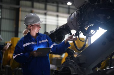Robot mühendisi fabrika deposunda robotik kolun bakımı üzerinde çalışıyor. İş teknolojisi.