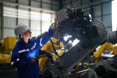 Robot mühendisi fabrika deposunda robotik kolun bakımı üzerinde çalışıyor. İş teknolojisi.