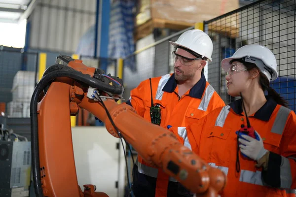 stock image Robotic Arm engineers checking equipment with software  of an Artificial Intelligence Computer Processor Unit