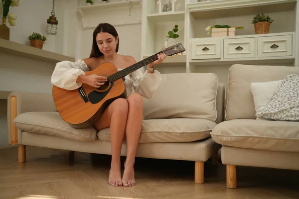 Młoda Piękna Kobieta Białej Bluzce Siedząca Kanapie Śpiewająca Piosenkę Gitarą — Zdjęcie stockowe