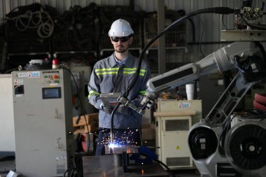 Robot mühendisi fabrika deposunda robotik kolun bakımı üzerinde çalışıyor. İş teknolojisi.