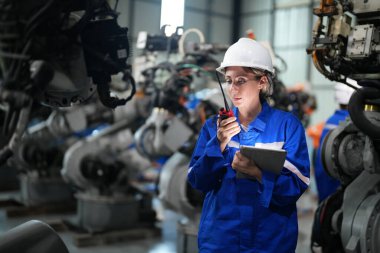 Robot mühendisi fabrika deposunda robotik kolun bakımı üzerinde çalışıyor. İş teknolojisi.