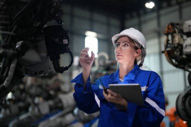 Robot mühendisi fabrika deposunda robotik kolun bakımı üzerinde çalışıyor. İş teknolojisi.