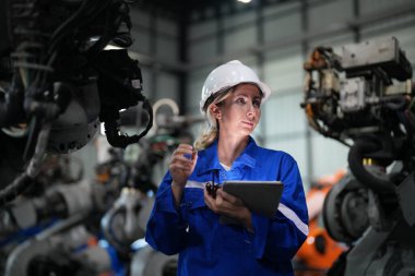 Robot mühendisi fabrika deposunda robotik kolun bakımı üzerinde çalışıyor. İş teknolojisi.