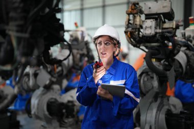 Robot mühendisi fabrika deposunda robotik kolun bakımı üzerinde çalışıyor. İş teknolojisi.