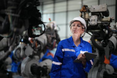 Robot mühendisi fabrika deposunda robotik kolun bakımı üzerinde çalışıyor. İş teknolojisi.