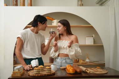 Genç ve güzel bir çift yemek pişiriyor ve gülümsüyor 