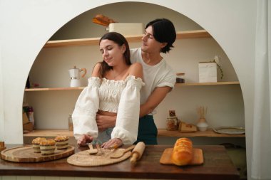 Mutlu genç çift mutfakta yemek pişiriyor. 