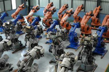 Robot mühendisi fabrika deposunda robotik kolun bakımı üzerinde çalışıyor. İş teknolojisi.