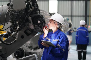 Robot mühendisi fabrika deposunda robotik kolun bakımı üzerinde çalışıyor. İş teknolojisi.