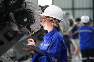 Robot mühendisi fabrika deposunda robotik kolun bakımı üzerinde çalışıyor. İş teknolojisi.