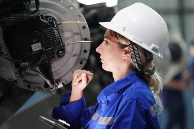 Robot mühendisi fabrika deposunda robotik kolun bakımı üzerinde çalışıyor. İş teknolojisi.