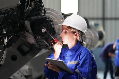 Robot mühendisi fabrika deposunda robotik kolun bakımı üzerinde çalışıyor. İş teknolojisi.