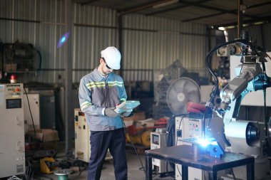 Robot mühendisi fabrika deposunda robotik kolun bakımı üzerinde çalışıyor. İş teknolojisi.