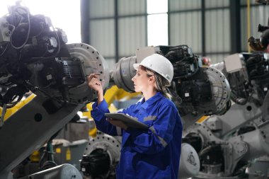 Robot mühendisi fabrika deposunda robotik kolun bakımı üzerinde çalışıyor. İş teknolojisi.