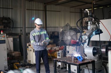 Robot mühendisi fabrika deposunda robotik kolun bakımı üzerinde çalışıyor. İş teknolojisi.