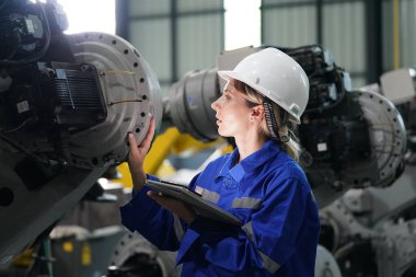 Robot mühendisi fabrika deposunda robotik kolun bakımı üzerinde çalışıyor. İş teknolojisi.