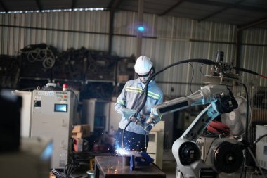 Robot mühendisi fabrika deposunda robotik kolun bakımı üzerinde çalışıyor. İş teknolojisi.