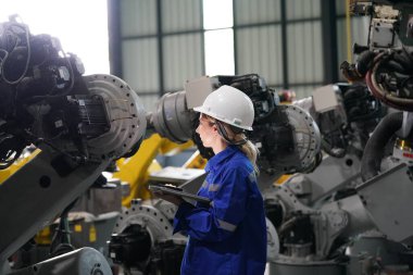 Robot mühendisi fabrika deposunda robotik kolun bakımı üzerinde çalışıyor. İş teknolojisi.