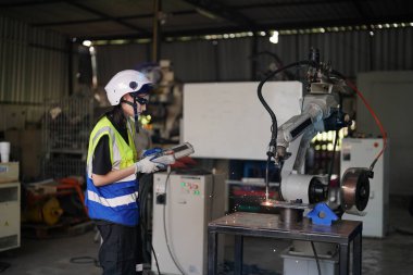 Robot mühendisi fabrika deposunda robotik kolun bakımı üzerinde çalışıyor. İş teknolojisi.