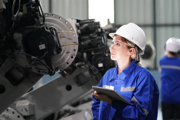 Robot mühendisi fabrika deposunda robotik kolun bakımı üzerinde çalışıyor. İş teknolojisi.