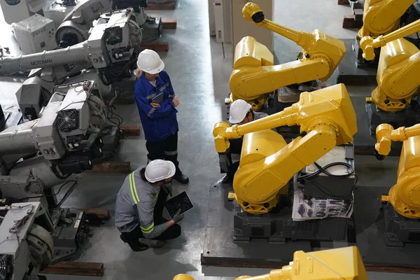 工場倉庫でロボットアームのメンテナンスを行うロボットエンジニア 事業技術 — ストック写真
