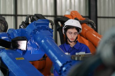 Robot mühendisi fabrika deposunda robotik kolun bakımı üzerinde çalışıyor. İş teknolojisi.