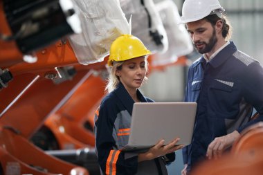 Robot mühendisi fabrika deposunda robotik kolun bakımı üzerinde çalışıyor. İş teknolojisi.