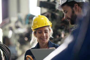 Robot mühendisi fabrika deposunda robotik kolun bakımı üzerinde çalışıyor. İş teknolojisi.