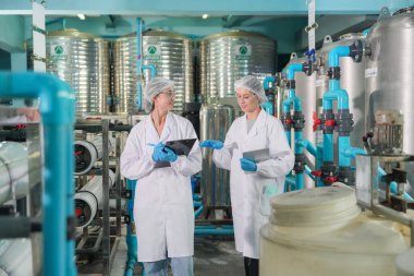 Sanayi için ters osmoz sisteminde çalışan kadınlar, endüstriyel kimya, elektrik santrali, petrol ve doğalgaz gibi tesislerde boru ile kurulması popüler ekipmanlar. Şişeleme fabrikasında genç ve mutlu kadın işçiler su şişelerini kontrol ediyor. 