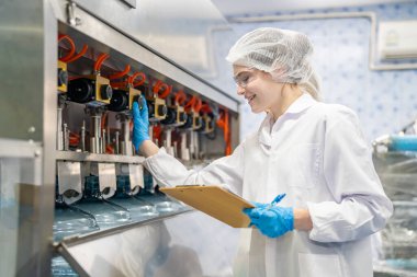 Elektrik santrali için ters osmoz sisteminde çalışan kadınlar. Endüstri için RO sistemi, endüstriyel kimyasallar, enerji santrali, petrol ve gaz gibi borularla kurulması popüler ekipmanlar. Şişeleme fabrikasında genç bayan işçiler su şişelerini kontrol ediyor. 