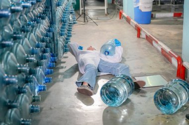 Depoda bir kadın kaza geçirir. Endüstriyel endüstri için RO sistemi, endüstriyel kimyasallar, elektrik santrali gibi borularla kurulması popüler ekipmanlar. Şişeleme fabrikasında su şişelerini kontrol eden genç ve mutlu bir kadın işçi.  