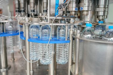 Elektrik santrali için ters osmoz sisteminde çalışan bir kadın. Endüstri için RO sistemi, endüstriyel kimyasallar, enerji santrali, petrol ve gaz gibi borularla kurulması popüler ekipmanlar. Şişeleme fabrikasında su şişelerini kontrol eden genç ve mutlu bir kadın işçi. 