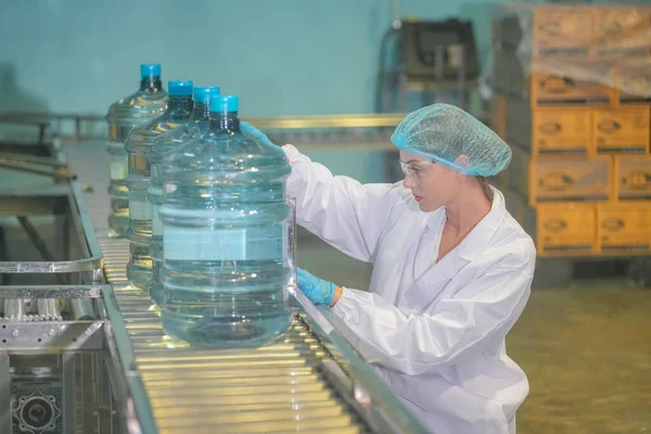 Woman working at Reverse osmosis system for power plant. RO system for industry, equipment which popular to install with pipe at industrial such chemical, power plant. Young happy female worker in bottling factory checking water bottles