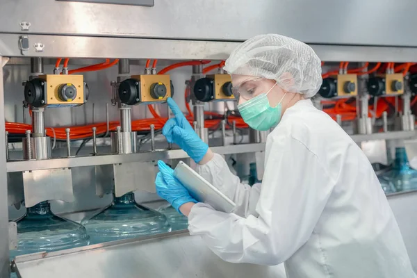 stock image Woman working at Reverse osmosis system for power plant. RO system for industry, equipment which popular to install with pipe at industrial such chemical, power plant, oil and gas. Young happy female worker in bottling factory checking water bottles