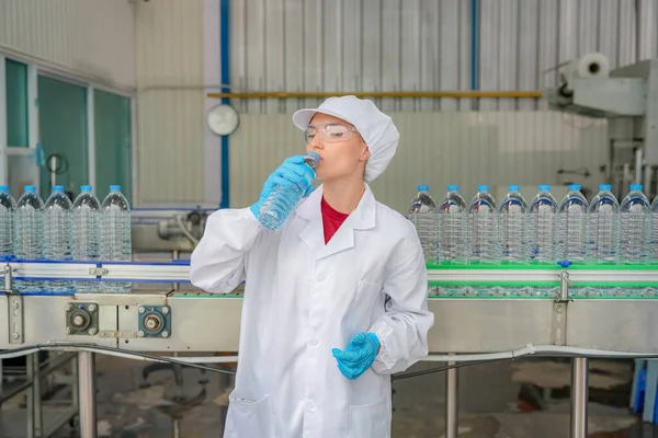 Woman working at Reverse osmosis system for power plant. RO system for industry, equipment which popular to install with pipe at industrial such chemical, power plant, oil and gas. Young female worker in bottling factory checking water bottles