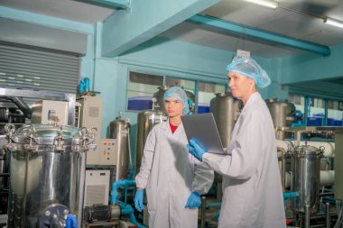 Elektrik santrali için ters osmoz sisteminde çalışan kadınlar. Endüstri için RO sistemi, endüstriyel kimyasallar, enerji santrali, petrol ve gaz gibi borularla kurulması popüler ekipmanlar. Şişeleme fabrikasında genç bayan işçiler su şişelerini kontrol ediyor. 