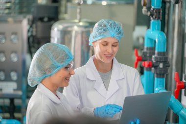 Elektrik santrali için ters osmoz sisteminde çalışan kadınlar. Endüstri için RO sistemi, endüstriyel kimyasallar, enerji santrali, petrol ve gaz gibi borularla kurulması popüler ekipmanlar. Şişeleme fabrikasında genç bayan işçiler su şişelerini kontrol ediyor. 