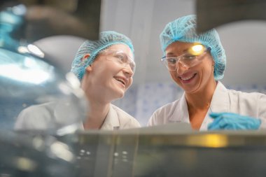 Elektrik santrali için ters osmoz sisteminde çalışan kadınlar. Endüstri için RO sistemi, endüstriyel kimyasallar, enerji santrali, petrol ve gaz gibi borularla kurulması popüler ekipmanlar. Şişeleme fabrikasında genç bayan işçiler su şişelerini kontrol ediyor. 