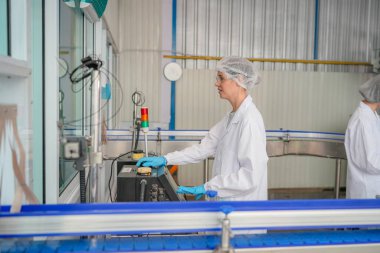 Elektrik santrali için ters osmoz sisteminde çalışan bir kadın. Endüstri için RO sistemi, endüstriyel kimyasallar, enerji santrali, petrol ve gaz gibi borularla kurulması popüler ekipmanlar. Şişeleme fabrikasında su şişelerini kontrol eden genç ve mutlu bir kadın işçi. 