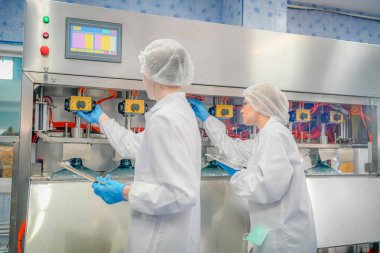 Elektrik santrali için ters osmoz sisteminde çalışan kadınlar. Endüstri için RO sistemi, endüstriyel kimyasallar, enerji santrali, petrol ve gaz gibi borularla kurulması popüler ekipmanlar. Şişeleme fabrikasında genç bayan işçiler su şişelerini kontrol ediyor. 