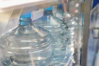 Elektrik santrali için ters osmoz sisteminde çalışan bir kadın. Endüstri için RO sistemi, endüstriyel kimyasallar, enerji santrali, petrol ve gaz gibi borularla kurulması popüler ekipmanlar. Şişeleme fabrikasında su şişelerini kontrol eden genç ve mutlu bir kadın işçi. 