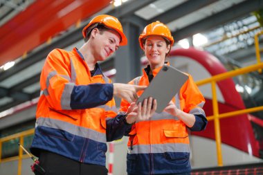 Demiryolu mühendisliği tesisinde lokomotifi inceleyen mühendisler