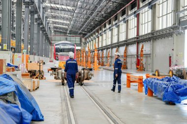 Demiryolu mühendisliği tesisinde lokomotifi inceleyen mühendisler