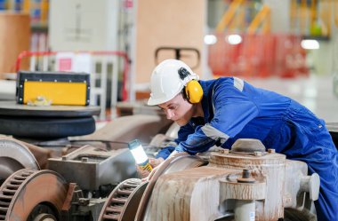 Demiryolu mühendisliği tesisinde lokomotifi inceleyen mühendisler
