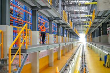 Demiryolu mühendisliği tesisinde lokomotifi denetleyen mühendis.