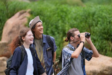 Yürüyüşçüler dağda yürüyüş sopalarıyla bir patika boyunca yürüyorlar. Macera, seyahat, turizm, yürüyüş ve insan konsepti. Sırt çantalı bir grup gülen arkadaş..