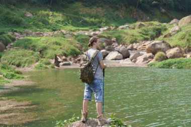 Yürüyüşçü dağda yürüyüş sopalarıyla bir patika boyunca yürüyor.. 