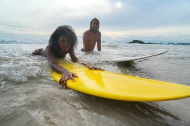 Pattaya, Tayland 'da sörf tahtasıyla sahilde sörf yapan mutlu çift..