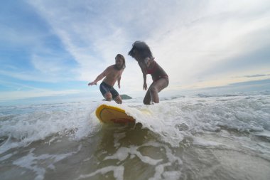 Pattaya, Tayland 'da sörf tahtasıyla sahilde sörf yapan mutlu çift..